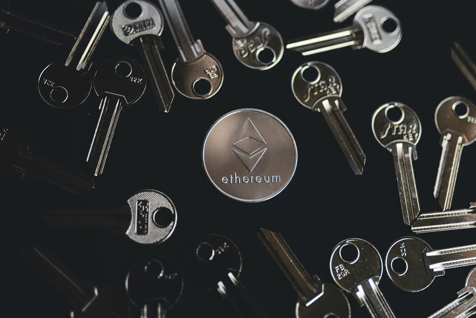 Physical keys surrounding a silver Ethereum token.