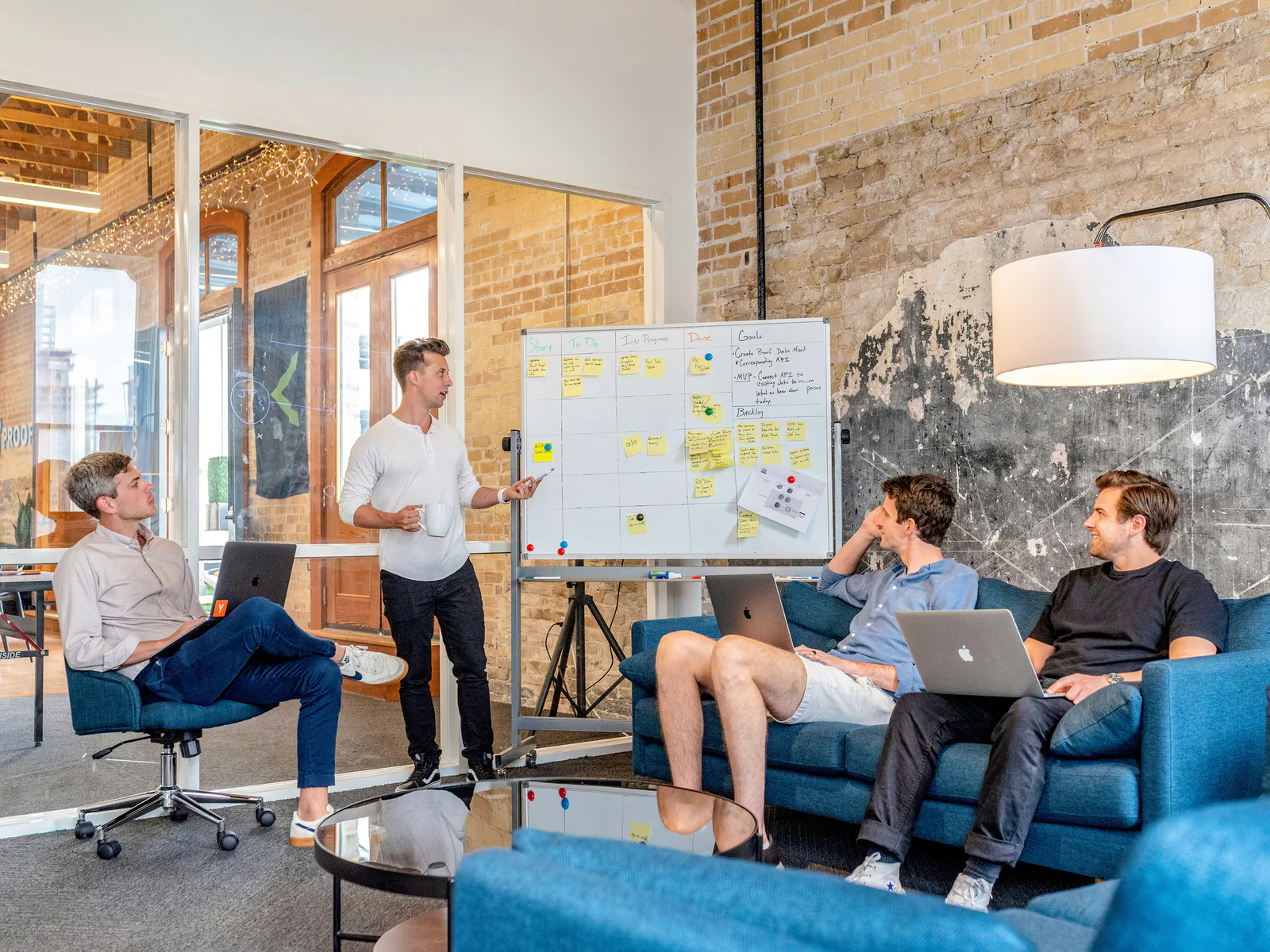 Startup team collaborating around a whiteboard in a bright office.